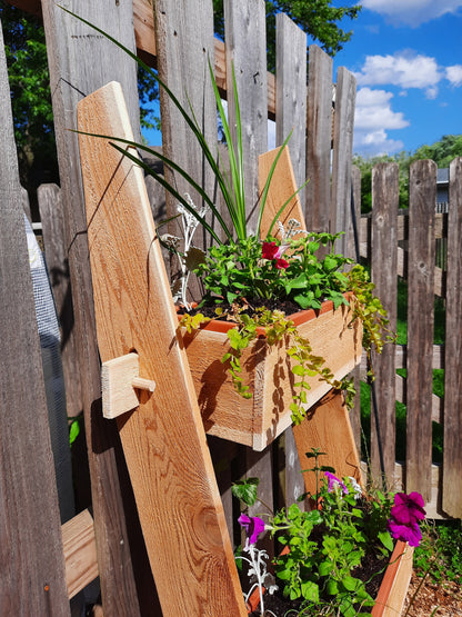 3-Tier Cedar Standing Planter Box Timberlane Gardens on a weathered fence with petunias on Tampa Home & Garden Store