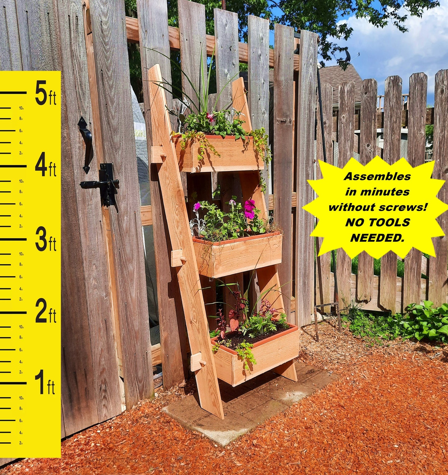 Timberlane Gardens 3-Tier Vertical Cedar Standing Planter Box with greenery on a wooden fence on Tampa Home & Garden Store
