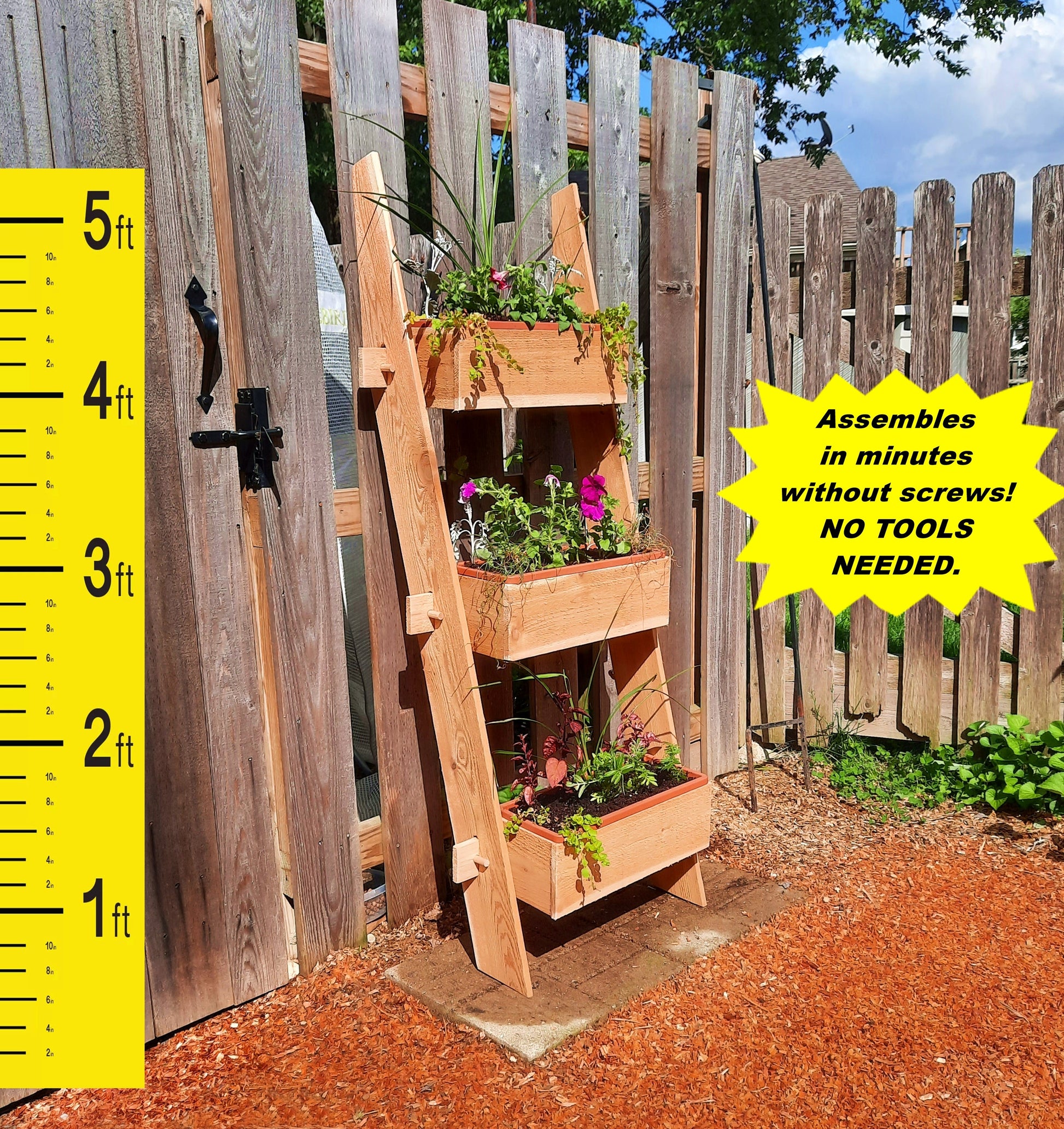 Timberlane Gardens 3-Tier Vertical Cedar Standing Planter Box with greenery on a wooden fence on Tampa Home & Garden Store