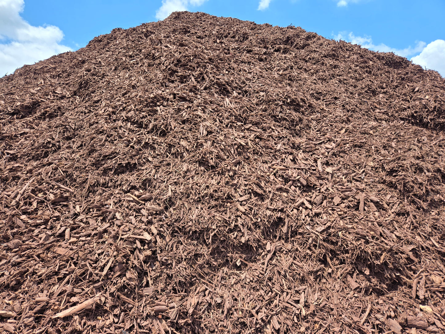 Pile of brown mulch for sale per cubic yard pricing.