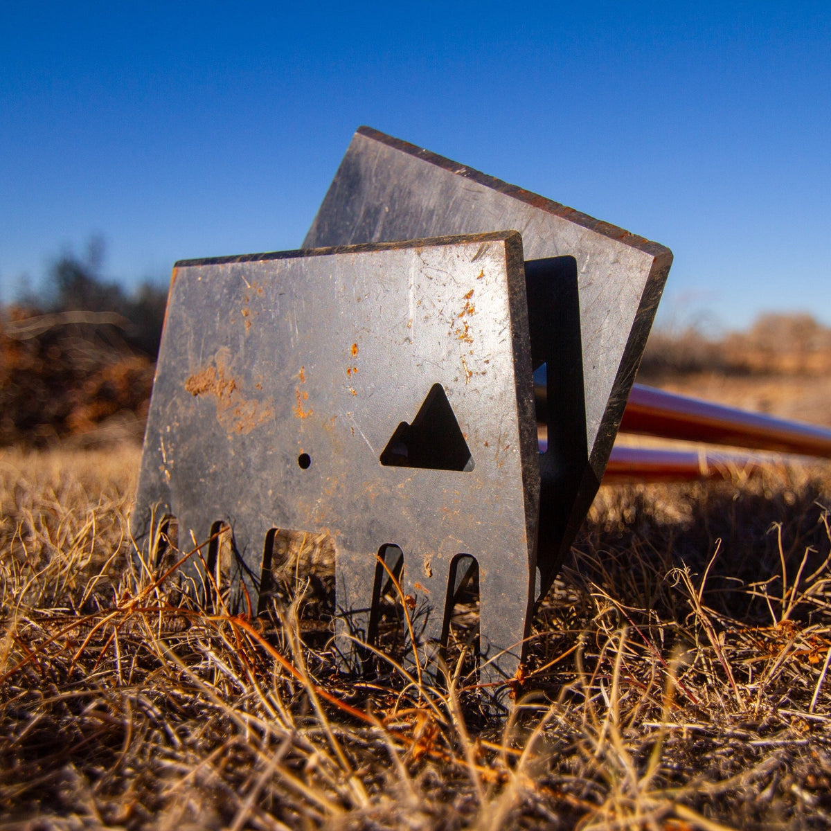Clyde rake head by Backslope Tools, steel with rust patina, stacked blades in field on Tampa Home & Garden Store