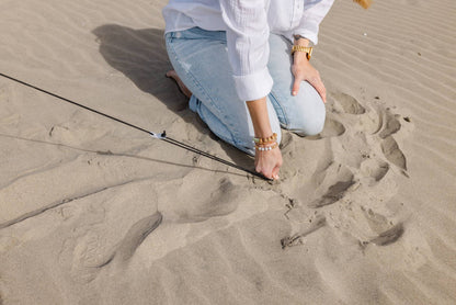 Pop 'N Go Canopy on sandy beach with a kneeling person in light jeans and white shirt on Tampa Home & Garden Store