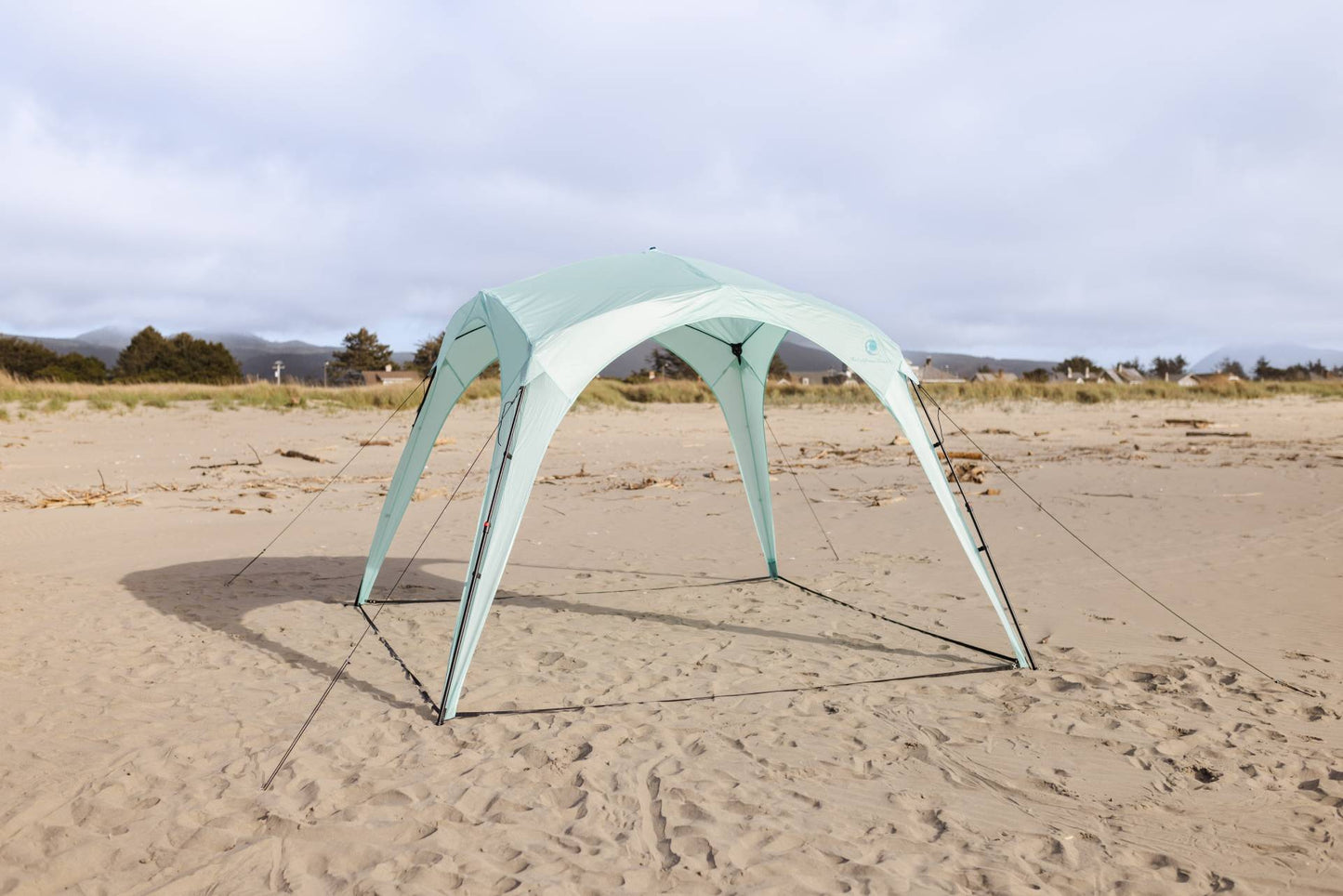 Pop 'N Go® Canopy mint-green beach canopy with curved legs on sandy shore by CA Beach Co. on Tampa Home & Garden Store