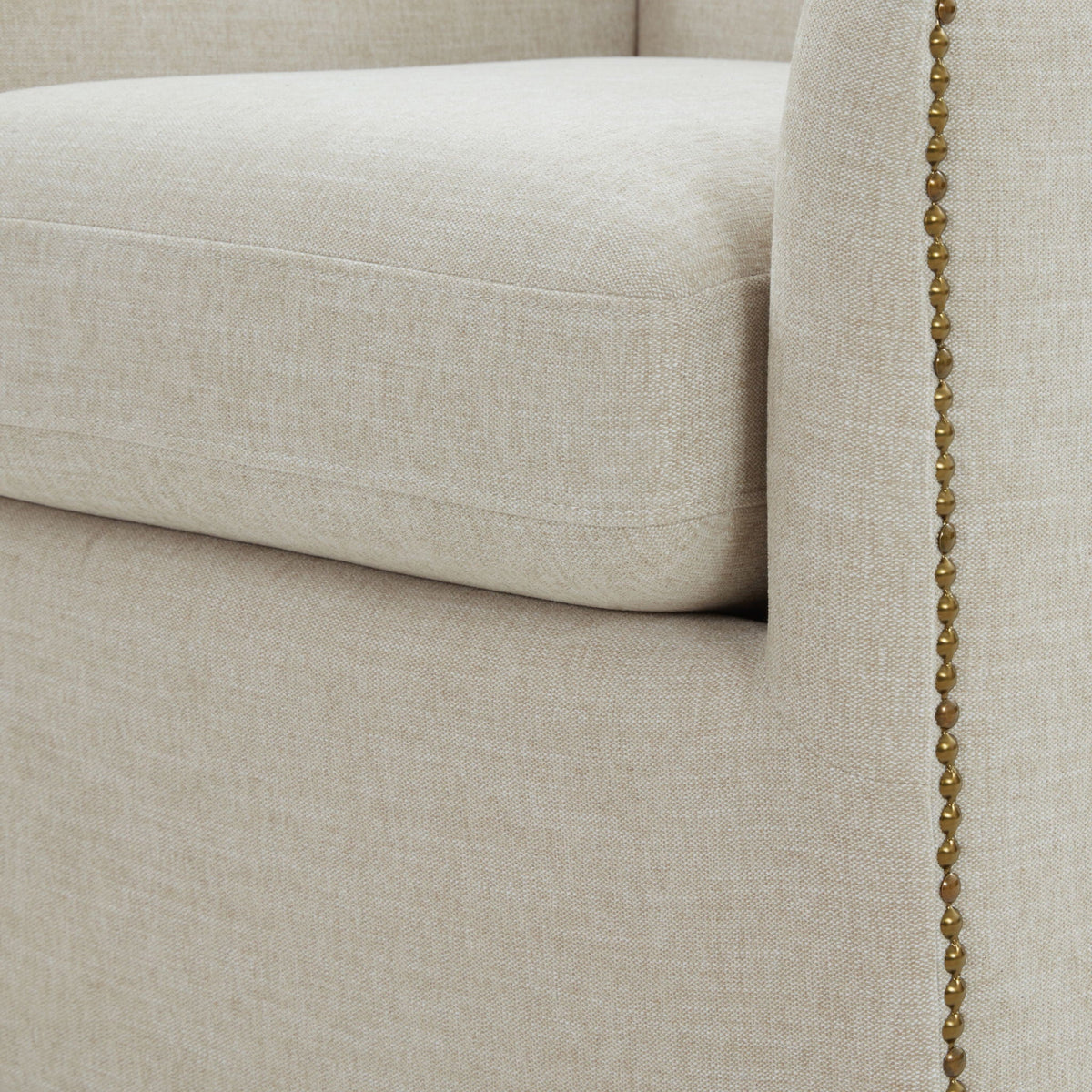Swivel chair beige upholstery with brass bead trim along seam on Tampa Home & Garden Store
