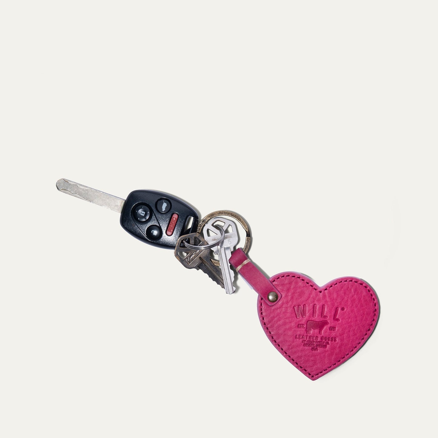 Heart-shaped pink leather keychain with Will Leather Goods branding and attached keys on Tampa Home & Garden Store