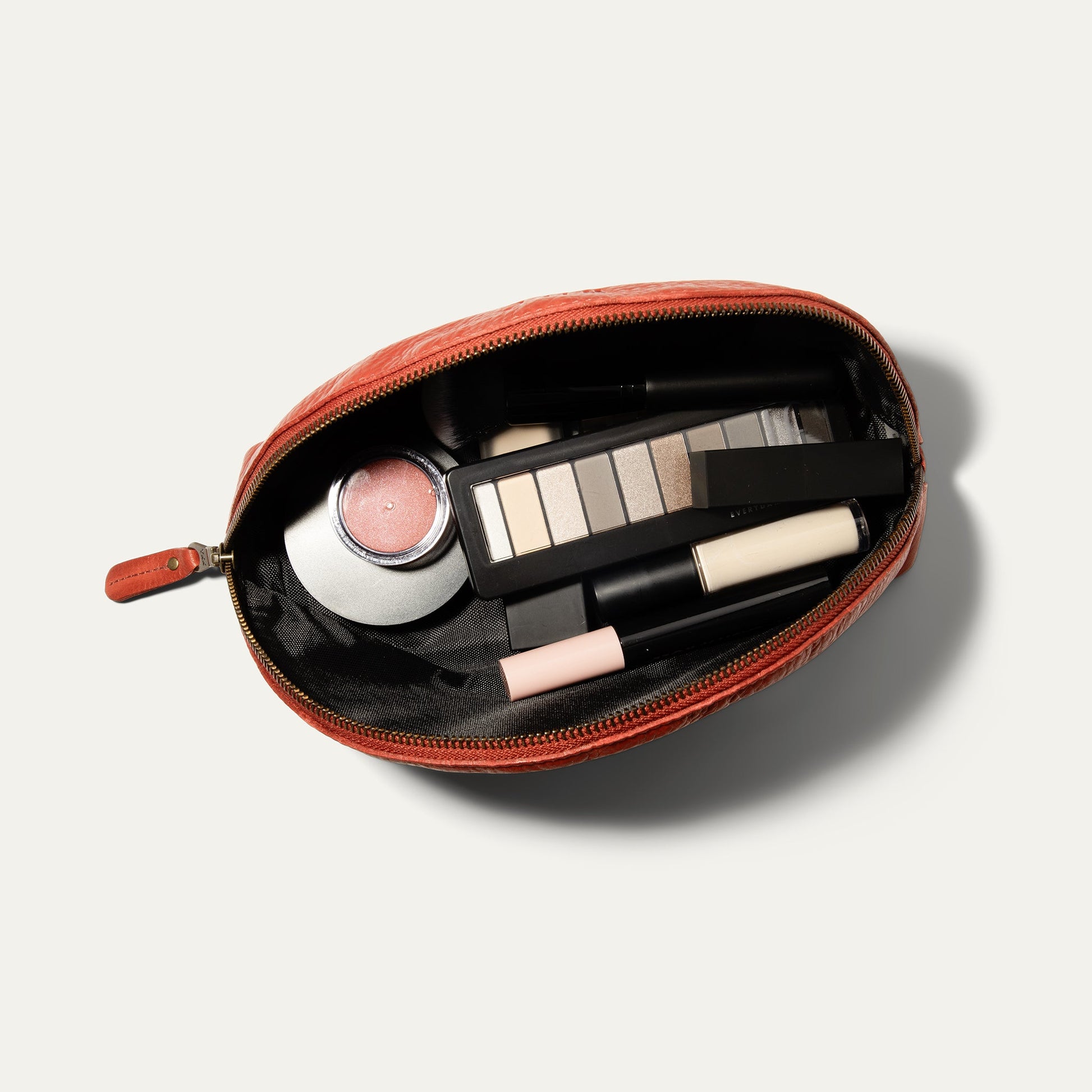Zip Cosmetic bag by Will Leather Goods in coral leather, open to makeup palette and lipstick on Tampa Home & Garden Store