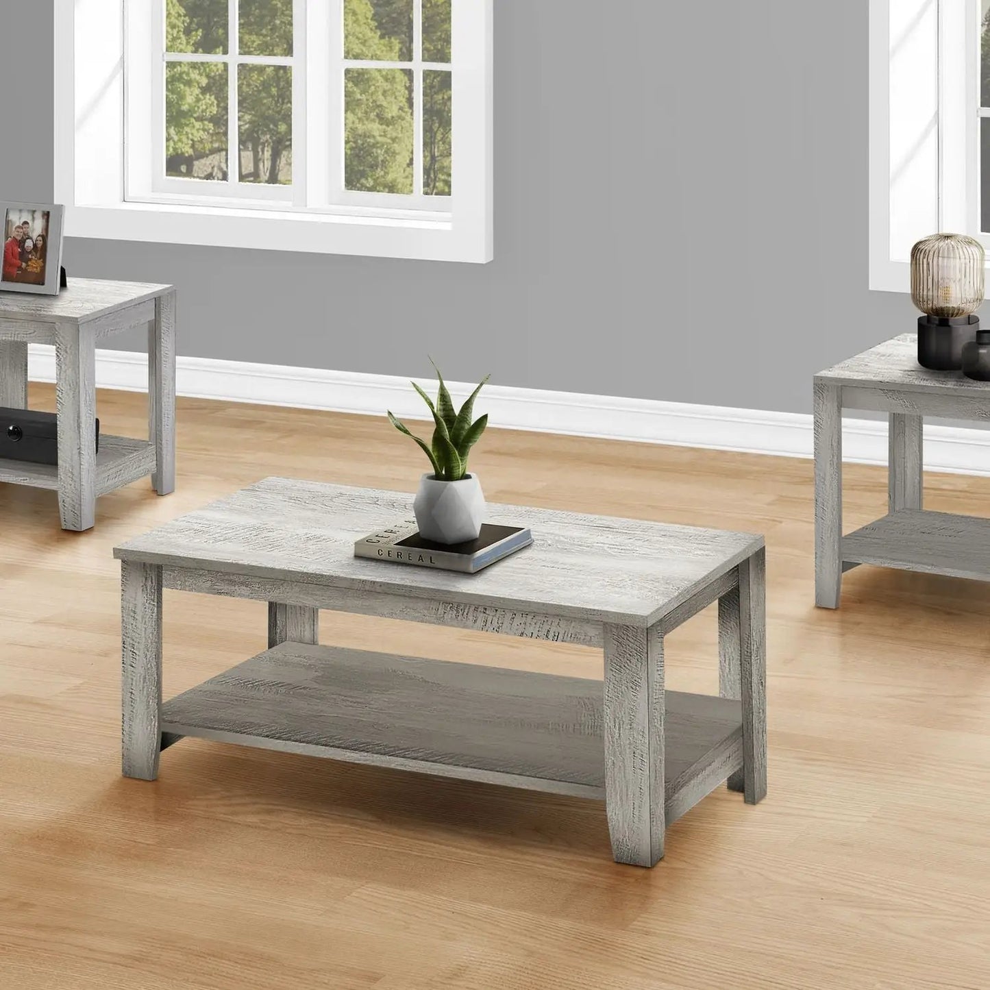 Table set of 3 gray-washed wood coffee and end tables in a living room with plant and decor on Tampa Home & Garden Store
