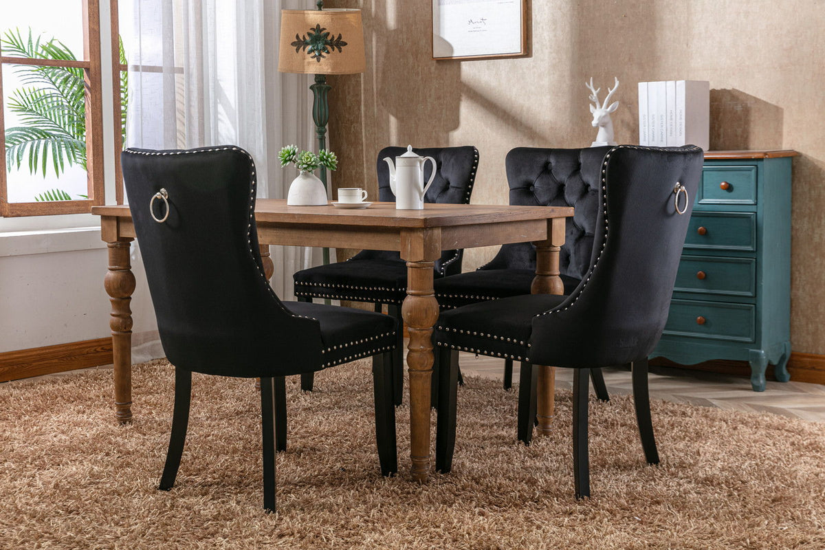 Tufted black velvet dining chairs set with nailhead trim and back ring pulls around a table on Tampa Home & Garden Store