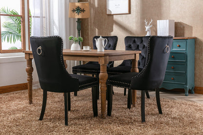 Tufted black velvet dining chairs set with nailhead trim and back ring pulls around a table on Tampa Home & Garden Store