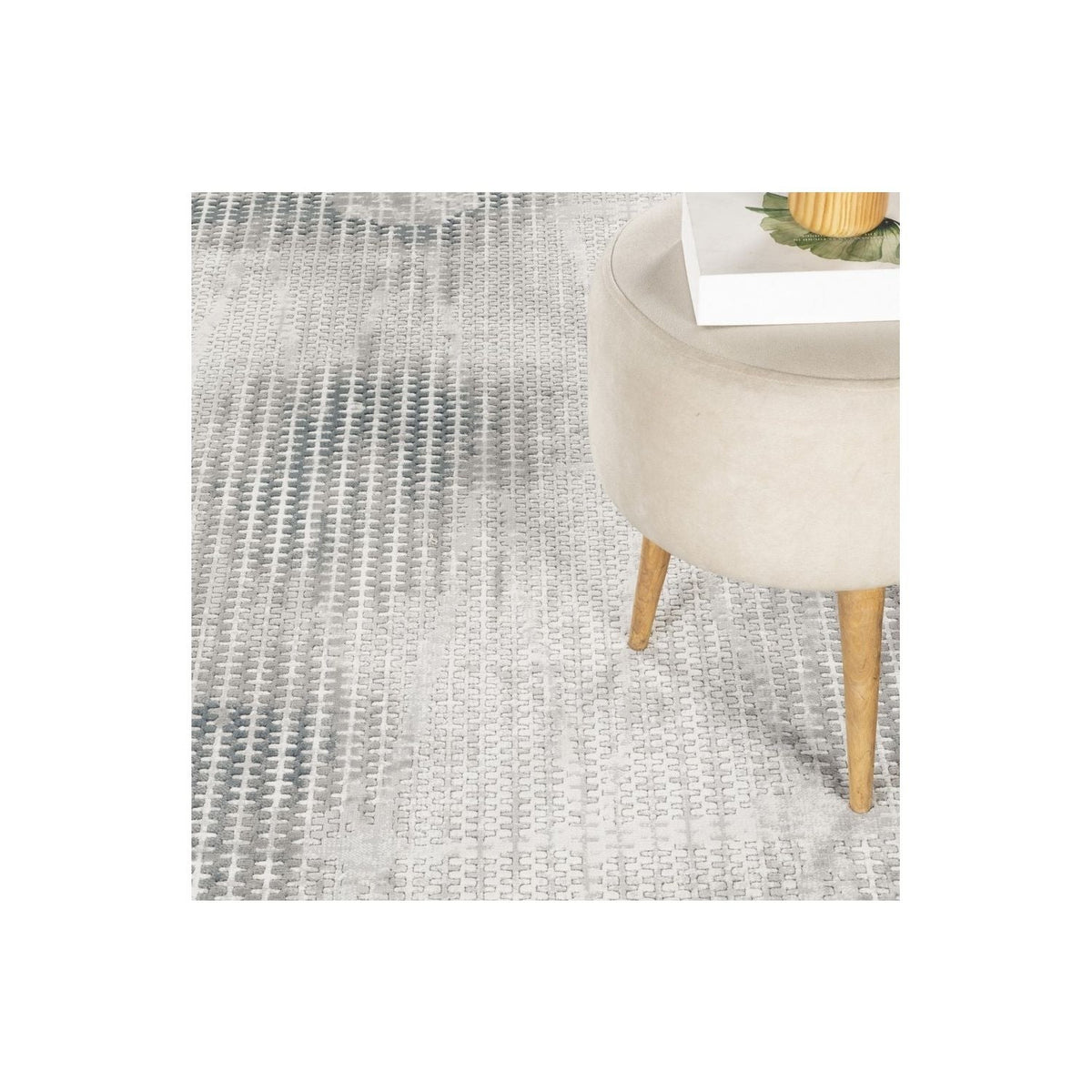 Modern Ivory and Gray Geometric Area Rug with gray motif under a beige chair with wood legs on Tampa Home & Garden Store