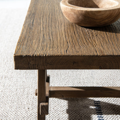 Trestle coffee table in reclaimed elm with brown finish; grain with wooden bowl on Tampa Home & Garden Store