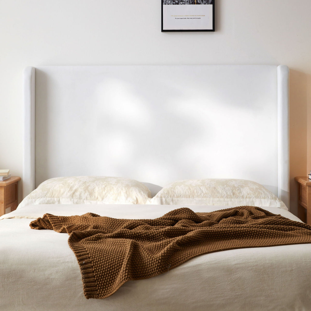 Carmen king size upholstered wingback bed in white with tufted headboard, white linens, brown knit throw on Tampa Home & Garden Store