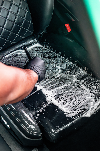 BLACKLINE Ultra-Soft Detail Brush used to scrub a black car interior seat with foam on Tampa Home & Garden Store