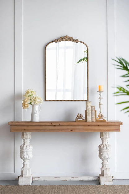 Arch Mirror with a gold-tone Baroque frame mounted above a rustic wooden console with flowers and books on Tampa Home & Garden Store