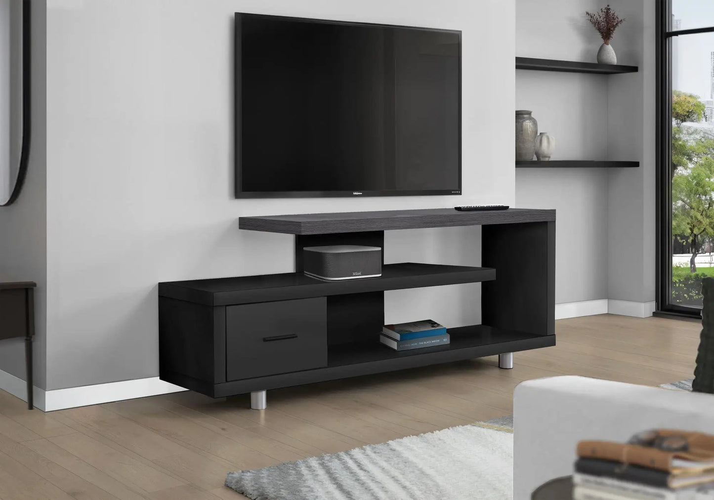 Black TV stand with shelves and a drawer beneath a wall-mounted flat-screen TV on Tampa Home & Garden Store