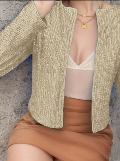 Elegant sequin cropped jacket in champagne gold, open-front with sparkle worn over beige top on Tampa Home & Garden Store