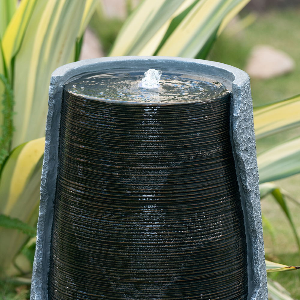 Indoor outdoor water fountain ribbed black stacked column in gray frame with top splash on Tampa Home & Garden Store