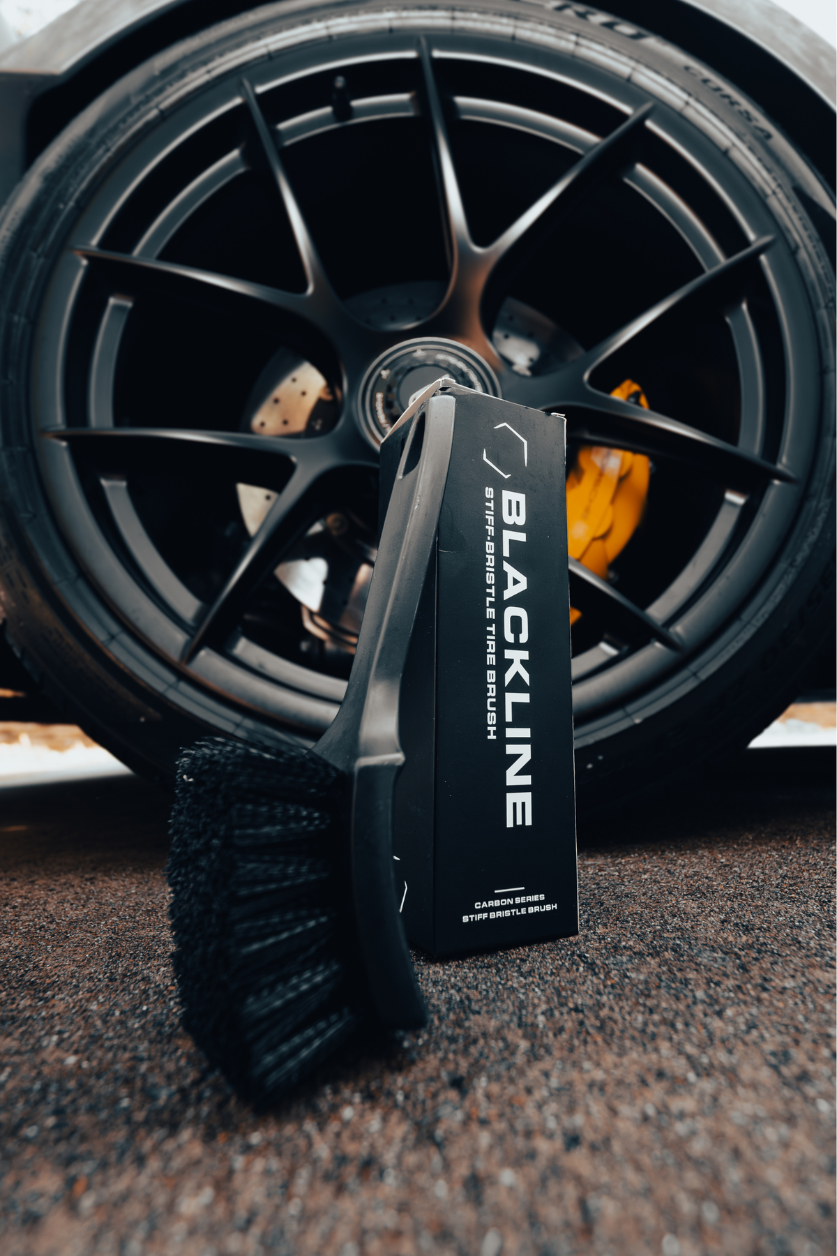 BLACKLINE Stiff Bristle Tire Brush with dense black bristles beside a dark alloy wheel on Tampa Home & Garden Store
