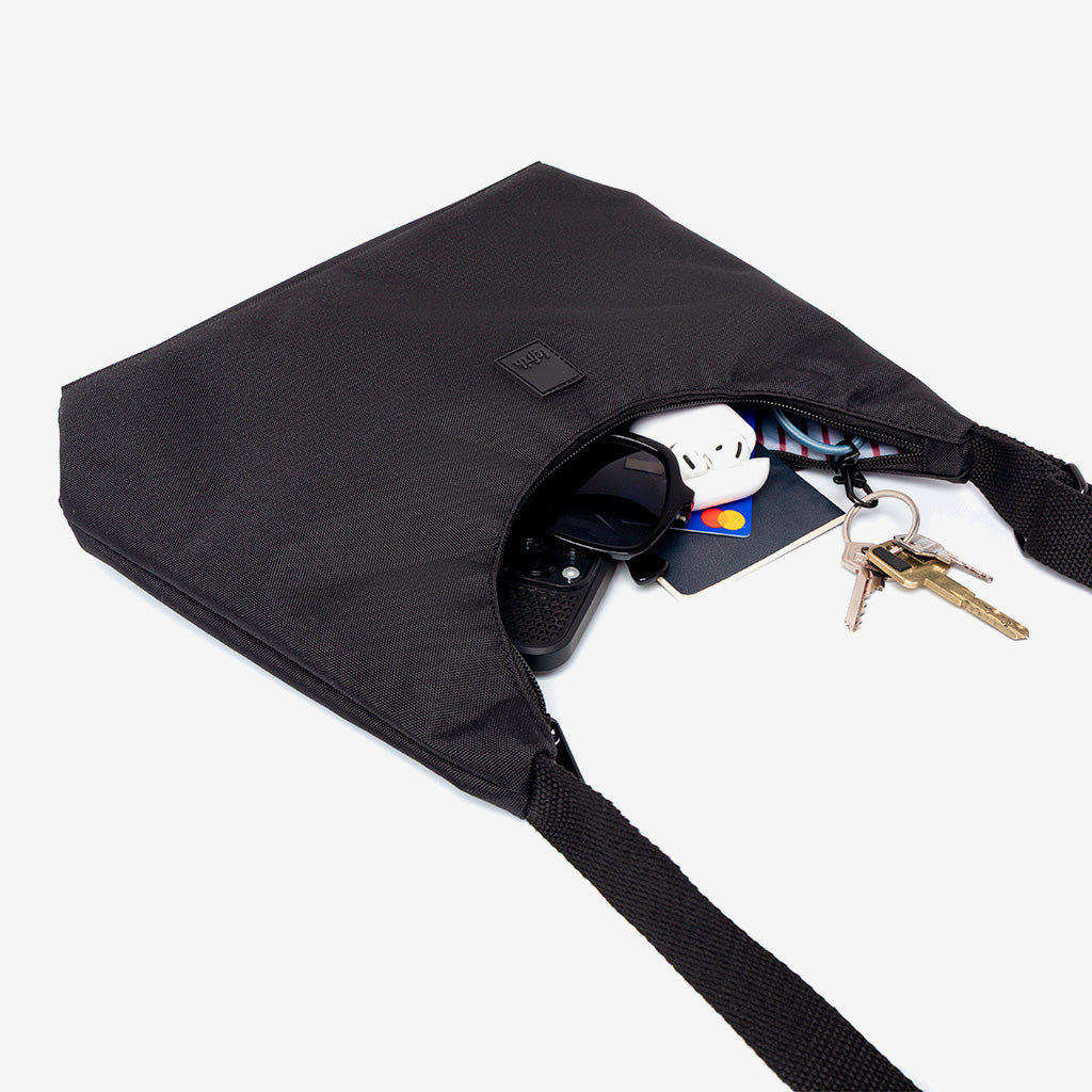 Bico Bag black crescent-shaped mini bag by Lefrik USA with crossbody strap and sunglasses, keys on Tampa Home & Garden Store