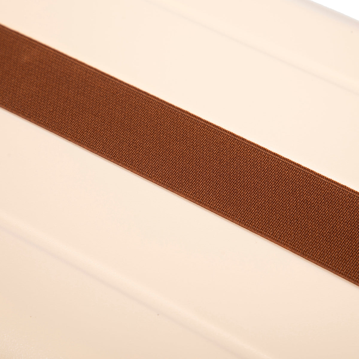 Luggage strap, brown woven belt across beige surface on Tampa Home & Garden Store
