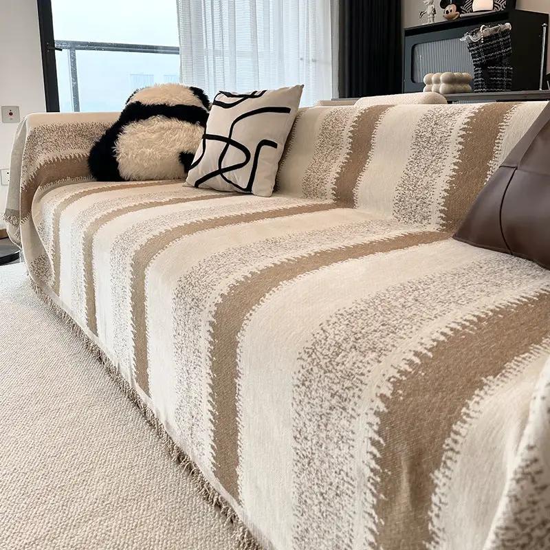 Sofa slipcover in beige and cream striped pattern with fringe edge on a living room couch on Tampa Home & Garden Store