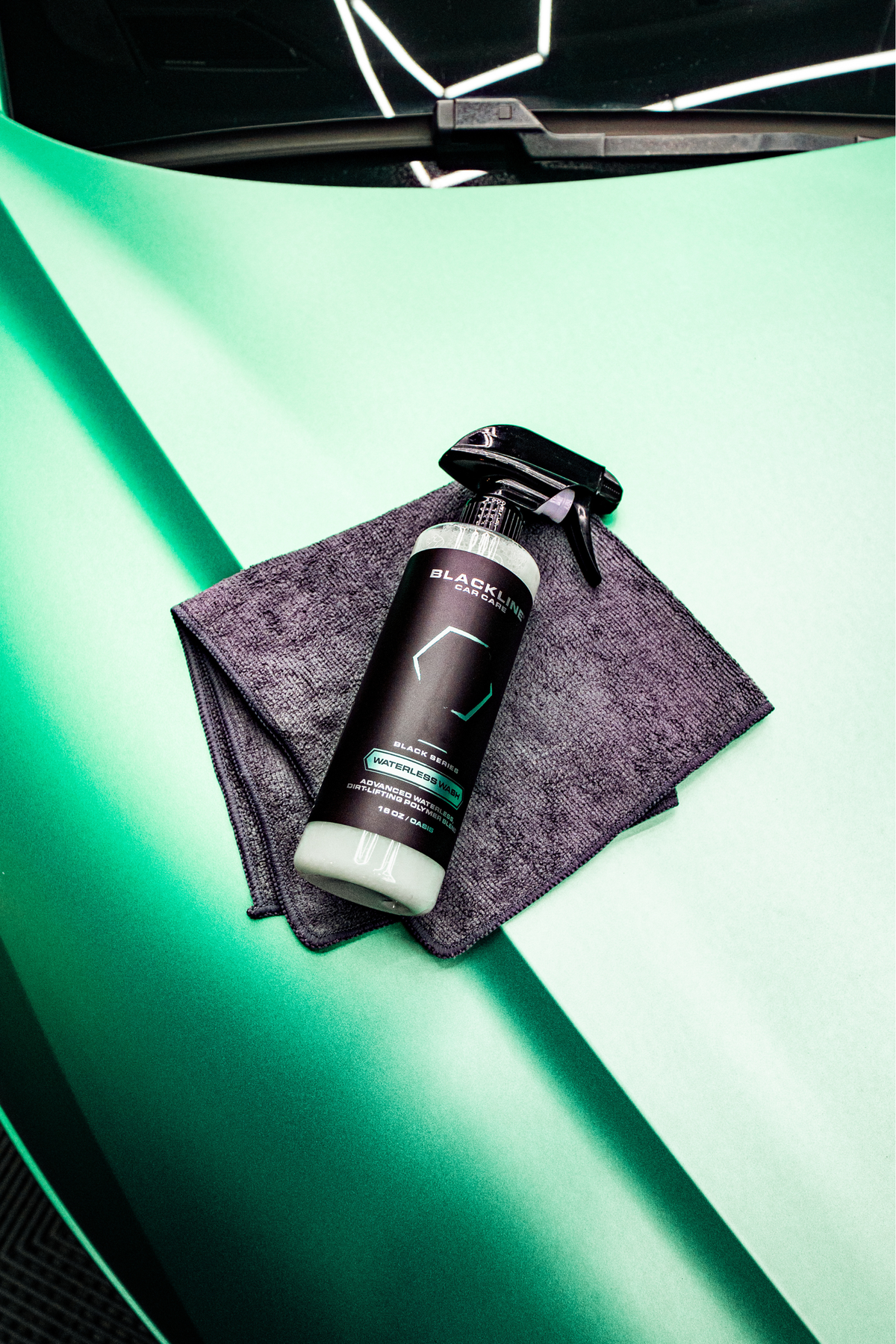 BLACKLINE Waterless Wash spray bottle on gray microfiber cloth against teal-green backdrop on Tampa Home & Garden Store