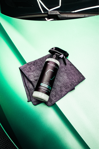 BLACKLINE Waterless Wash spray bottle on gray microfiber cloth against teal-green backdrop on Tampa Home & Garden Store