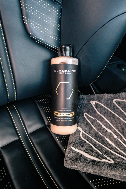 Leather conditioner BLACKLINE Rehydrate bottle on dark car leather seat by Blackline Car Care on Tampa Home & Garden Store
