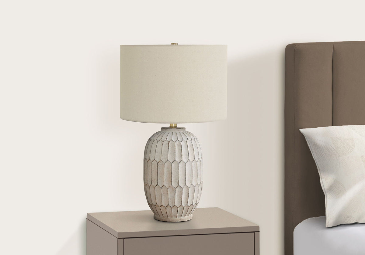 Table lamp with cream textile shade and textured cream ceramic base on a taupe nightstand on Tampa Home & Garden Store