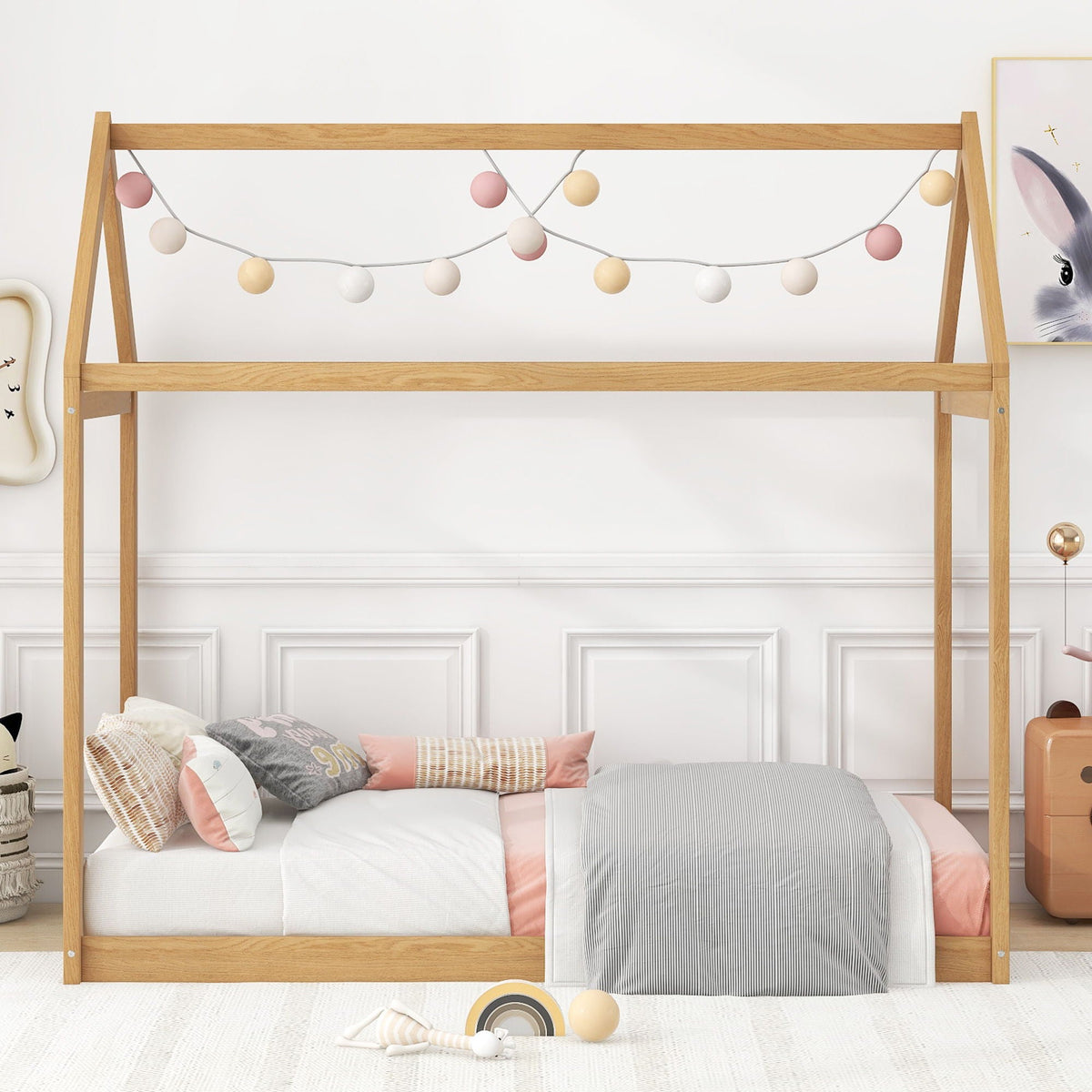 Wooden house-shaped platform bed frame in natural oak with pastel string lights on Tampa Home & Garden Store