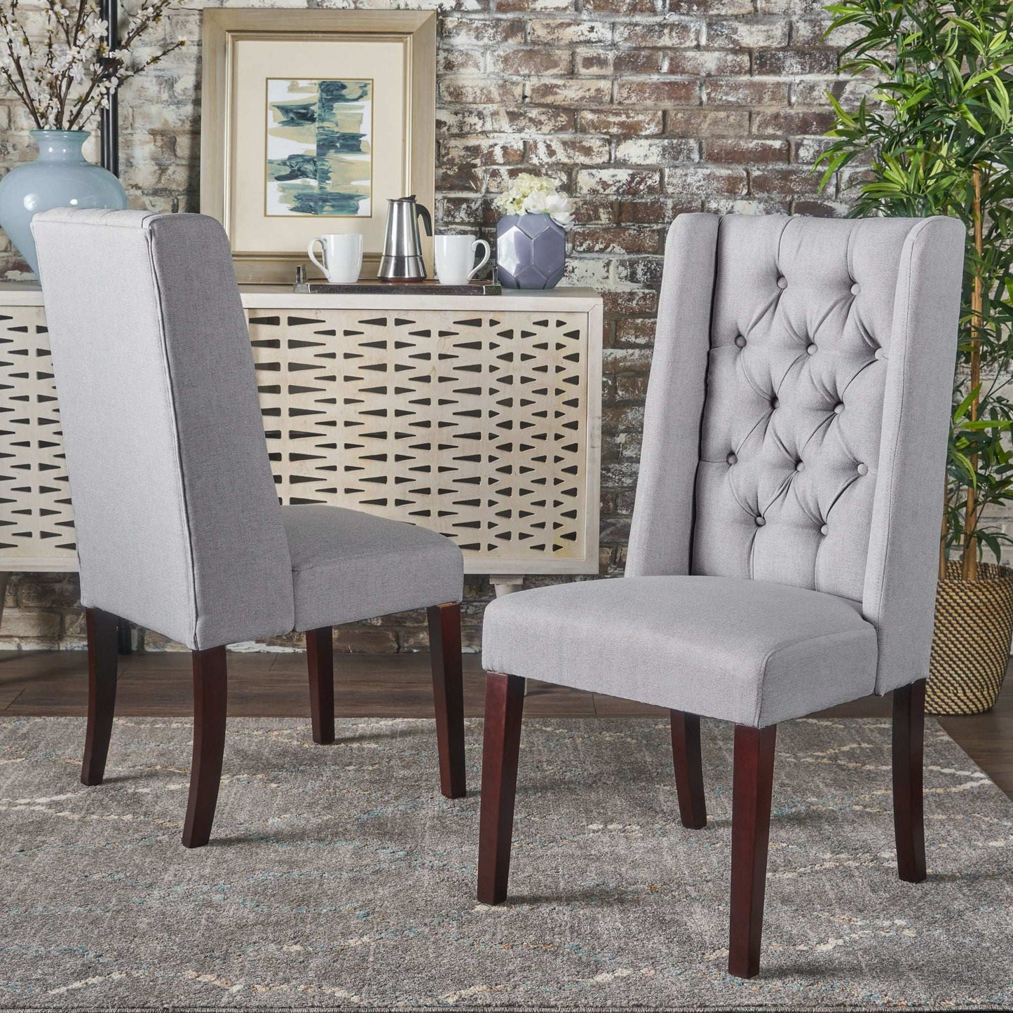 Set of sophisticated tufted dining chairs with high back in light gray fabric and dark wood legs on Tampa Home & Garden Store