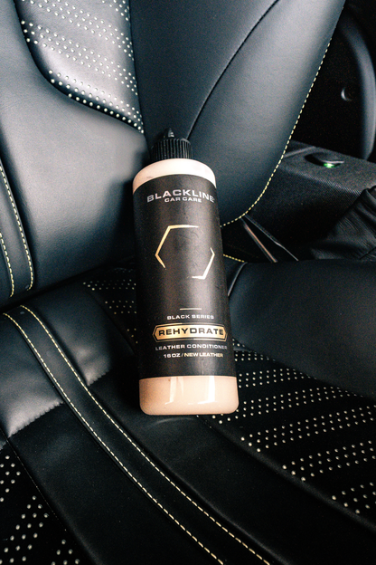 BLACKLINE Rehydrate Leather Conditioner bottle on black stitched leather car seat on Tampa Home & Garden Store