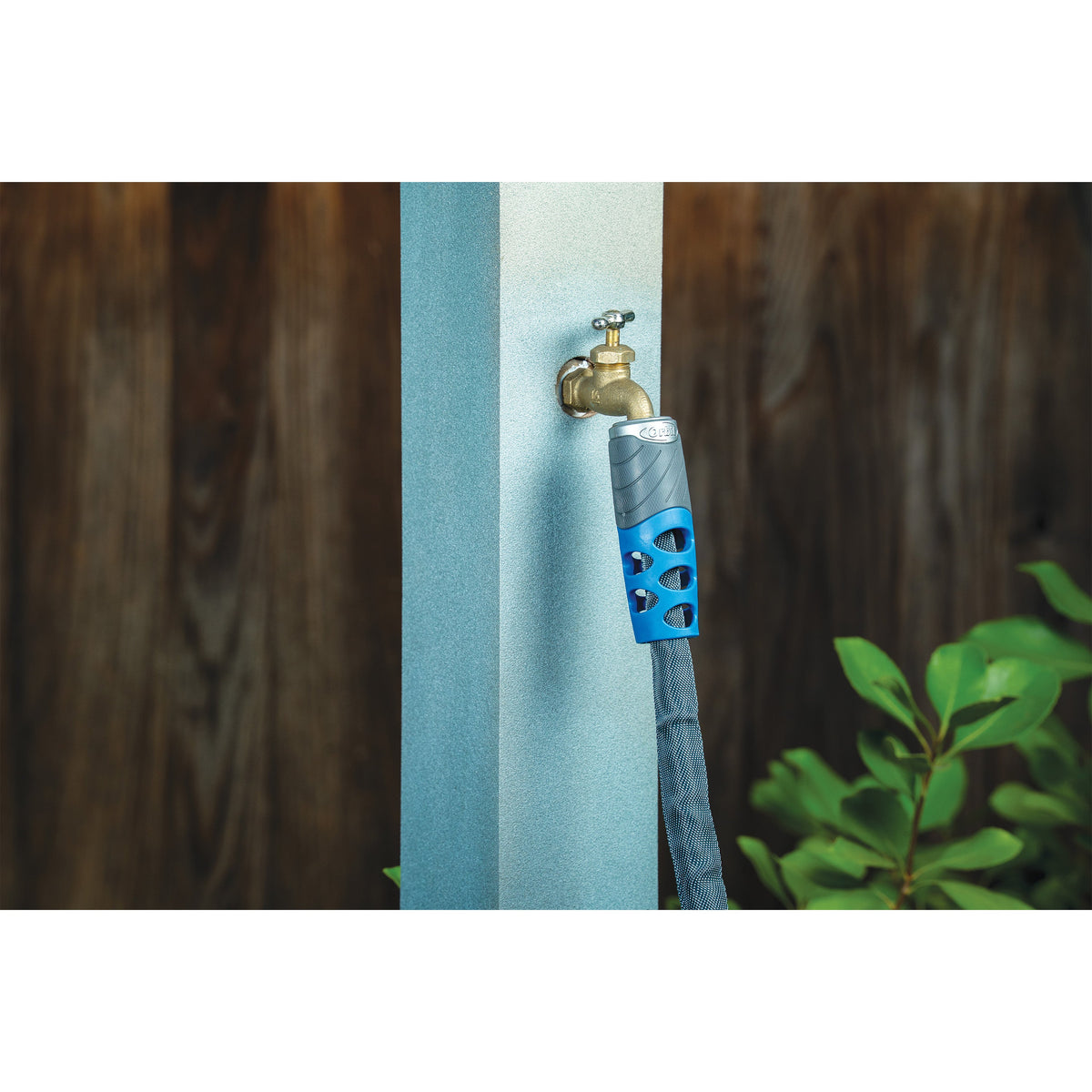 Orbit Elevated 100 ft heavy-duty fabric garden hose attached to outdoor spigot with blue grip on Tampa Home & Garden Store