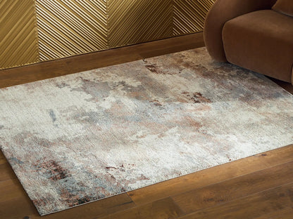 Jadenburg rug Unique Piece, beige-gray with rust accents beside brown sofa on wood floor on Tampa Home & Garden Store