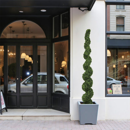 7FT spiral topiary tree, faux boxwood in a gray planter beside a storefront HouseOfZazla on Tampa Home & Garden Store