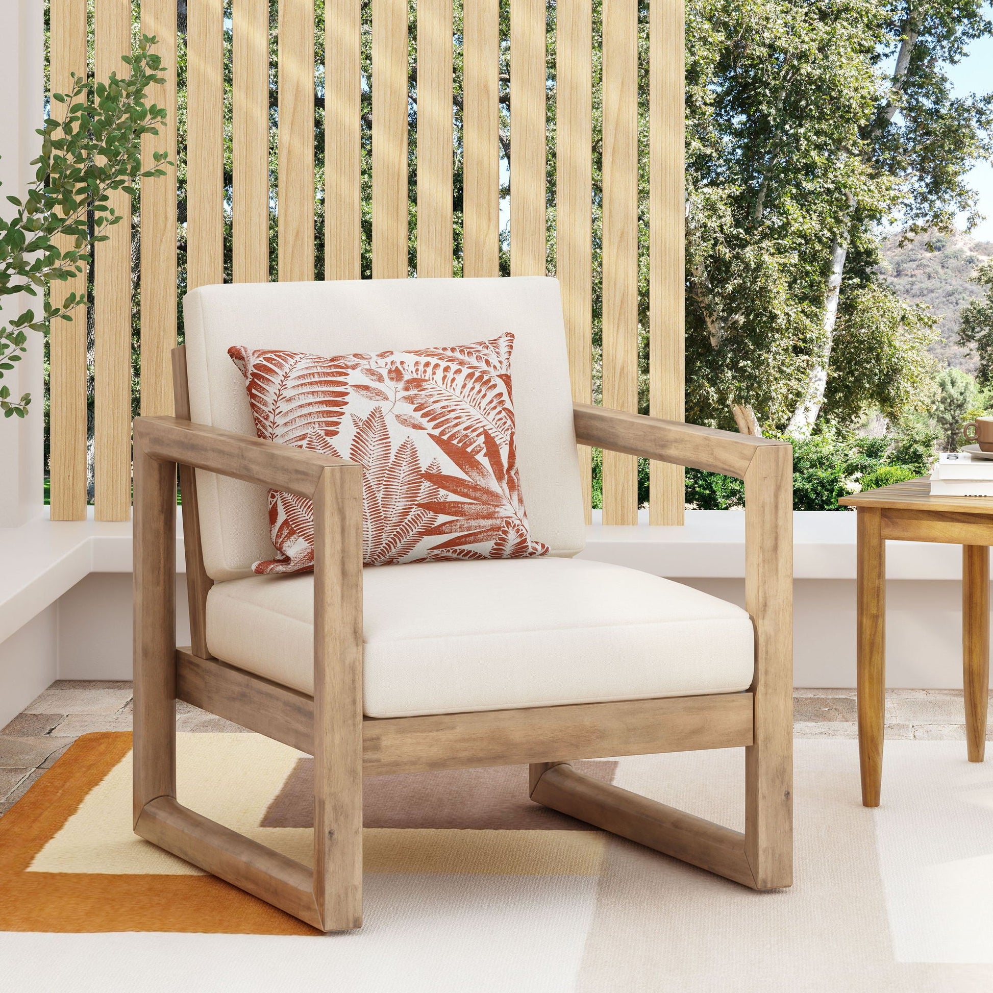 Outdoor Acacia Wood Patio Club Chair by HouseOfZazla with beige cushion and orange fern-pattern pillow on Tampa Home & Garden Store