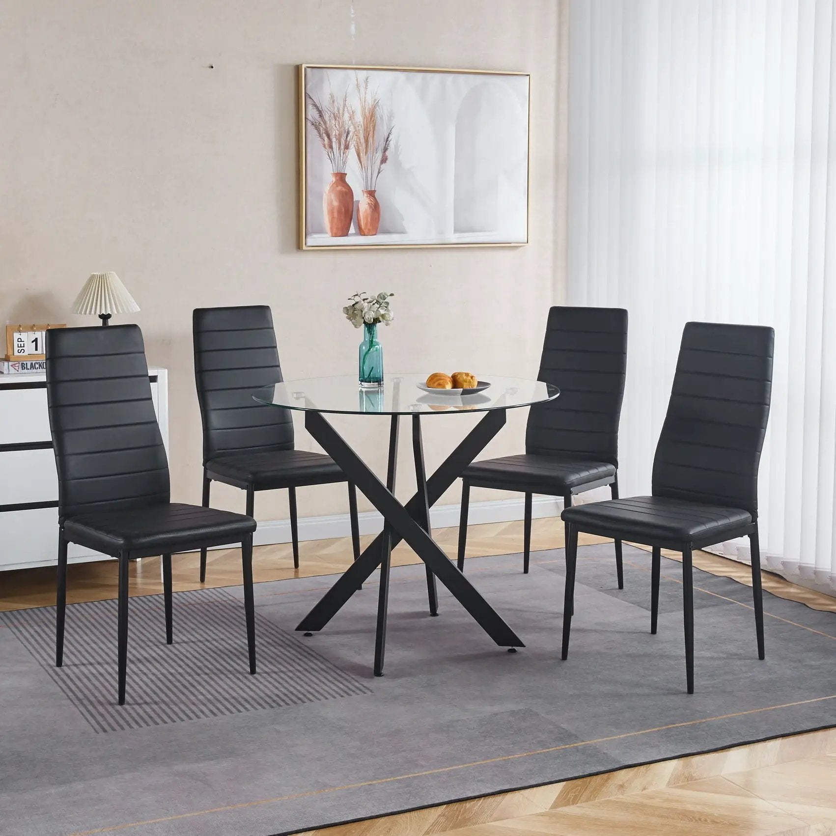 Dining table with cross metal legs and round tempered glass top, black leather chairs on Tampa Home & Garden Store