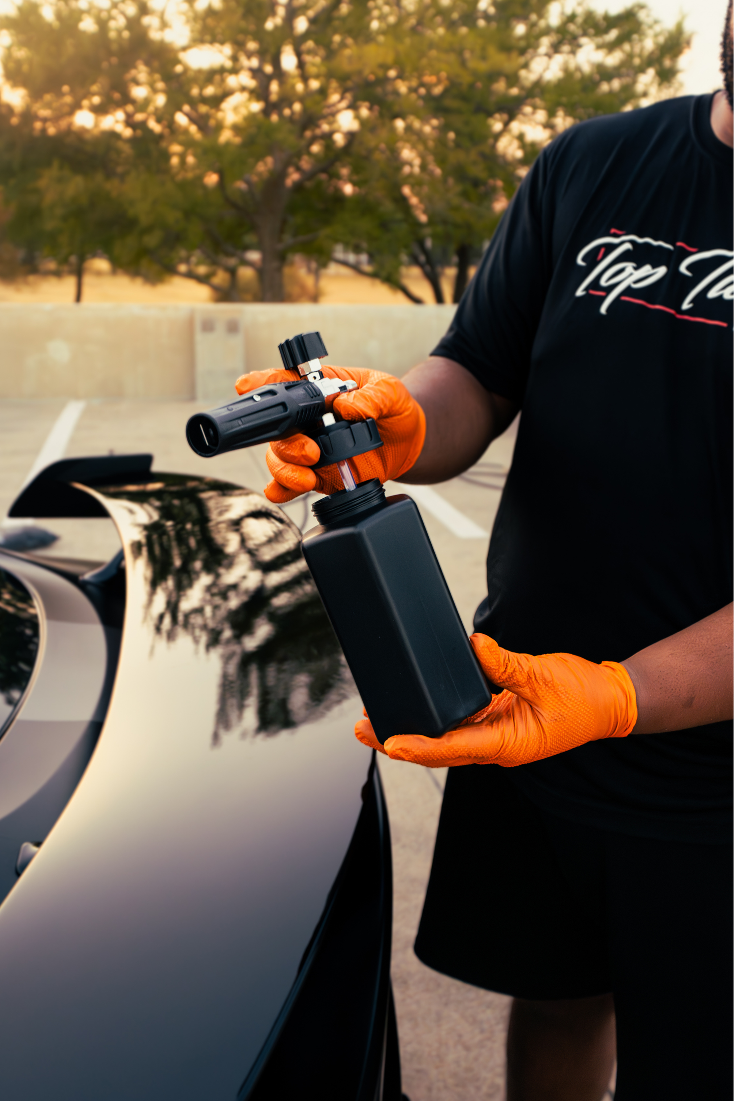 BLACKLINE Foam Cannon Pro, black foam cannon with adjustable nozzle held by orange gloves on Tampa Home & Garden Store