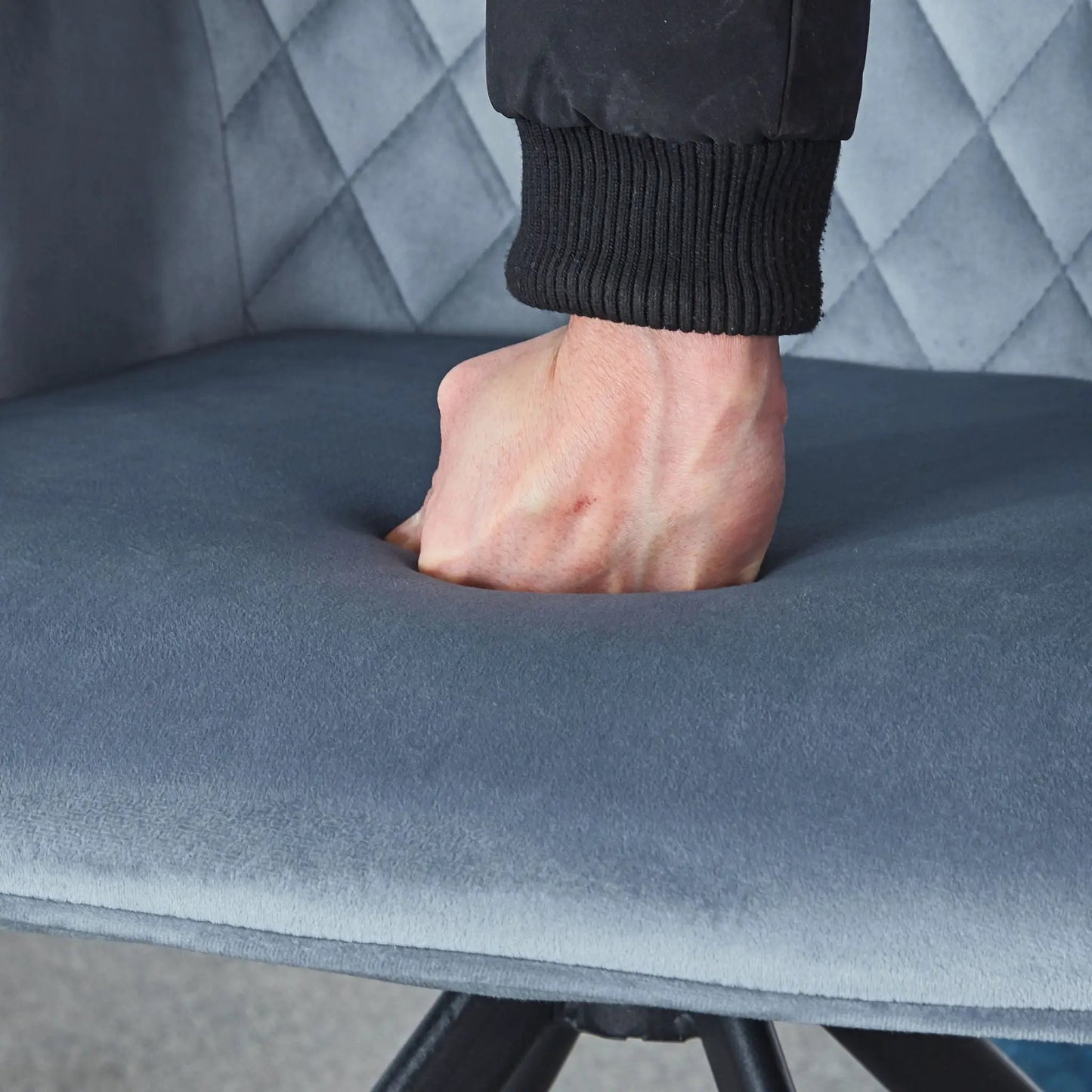 Modern desk chair close-up with ankle in black ribbed cuff on blue upholstery and metal leg on Tampa Home & Garden Store