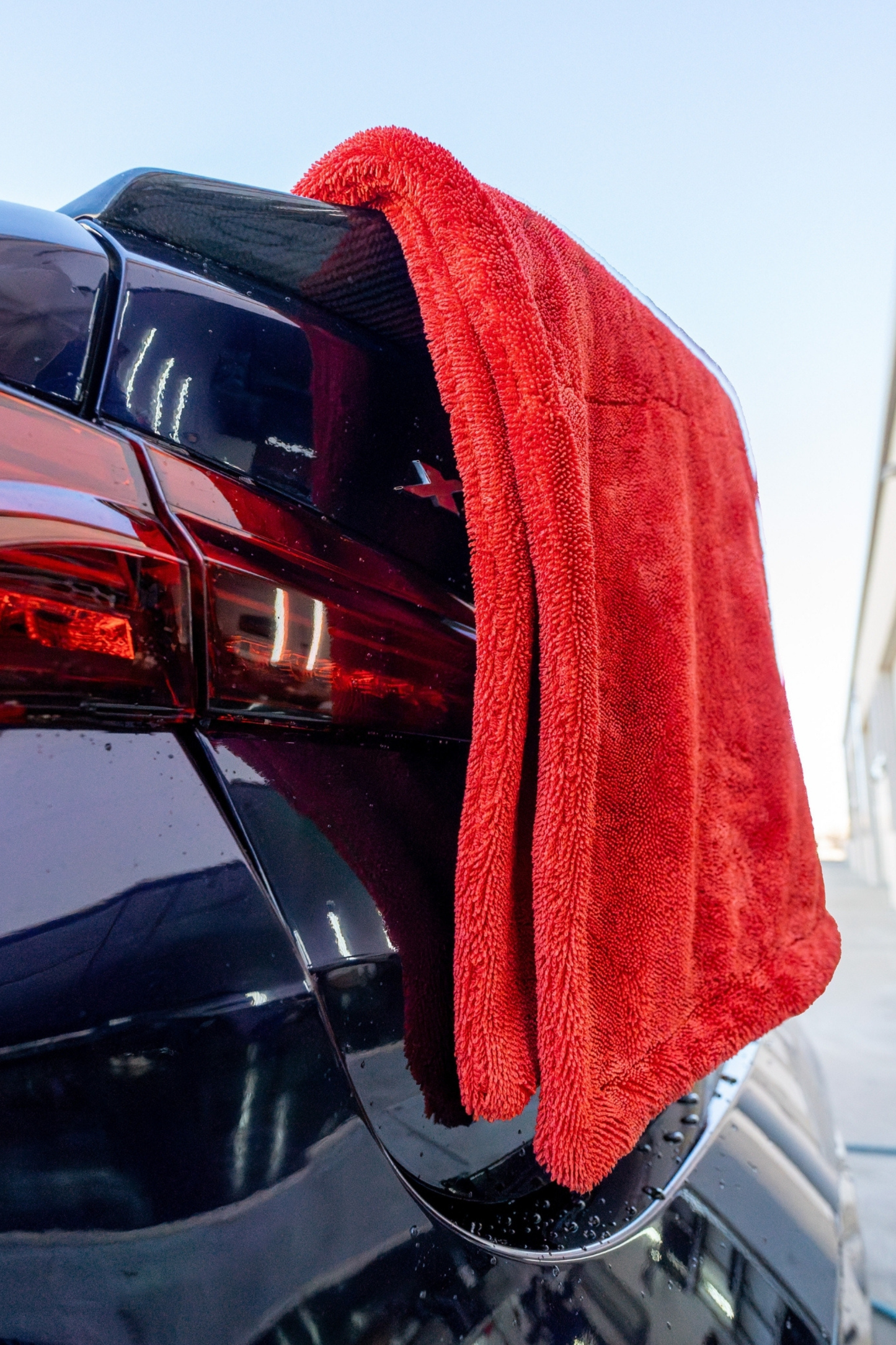BLACKLINE twisted-loop drying towel in red, microfiber car wash towel draped over a car tail on Tampa Home & Garden Store