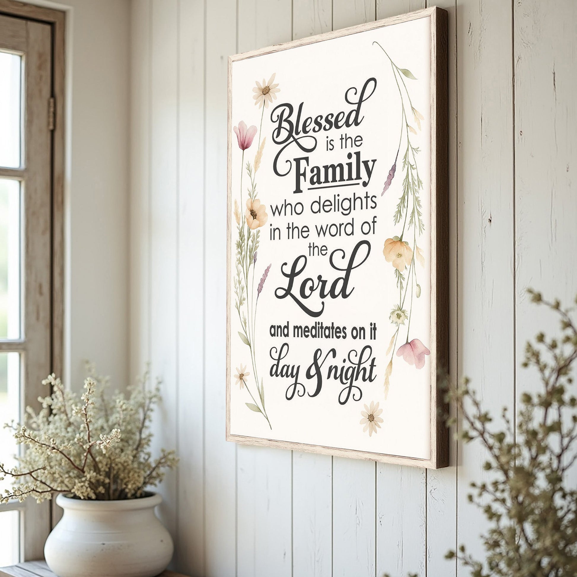 Blessed Is The Family faith sign canvas with light wood frame and floral border on a white wall on Tampa Home & Garden Store
