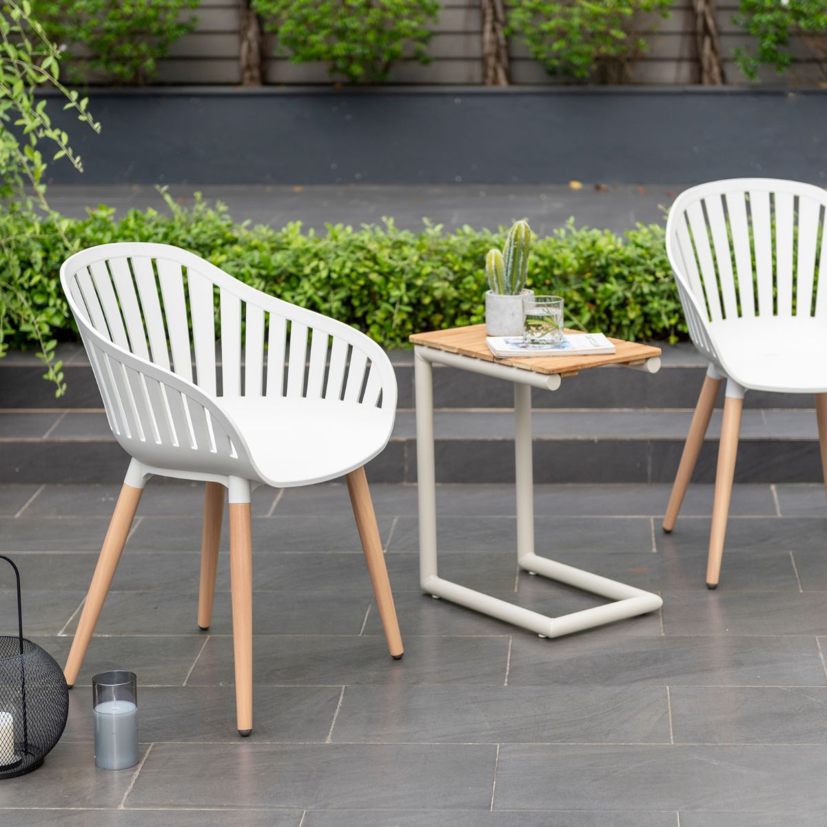 Two Portals Light C-shape outdoor chairs, white with wood legs, with small wooden-top table on Tampa Home & Garden Store