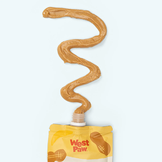 West Paw Peanut Butter Banana Gourmet Dog Treats creamy peanut butter swirl from a squeezable tube above yellow packaging on Tampa Home & Garden Store