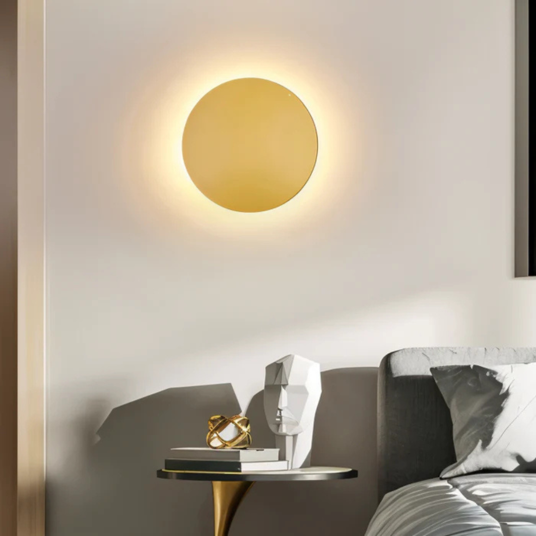 Modern LED Wall Lamp with round golden disc, warm backlit glow on white wall on Tampa Home & Garden Store