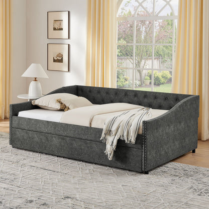 Upholstered grey daybed with nailhead trim and pull-out trundle in a bright bedroom on Tampa Home & Garden Store
