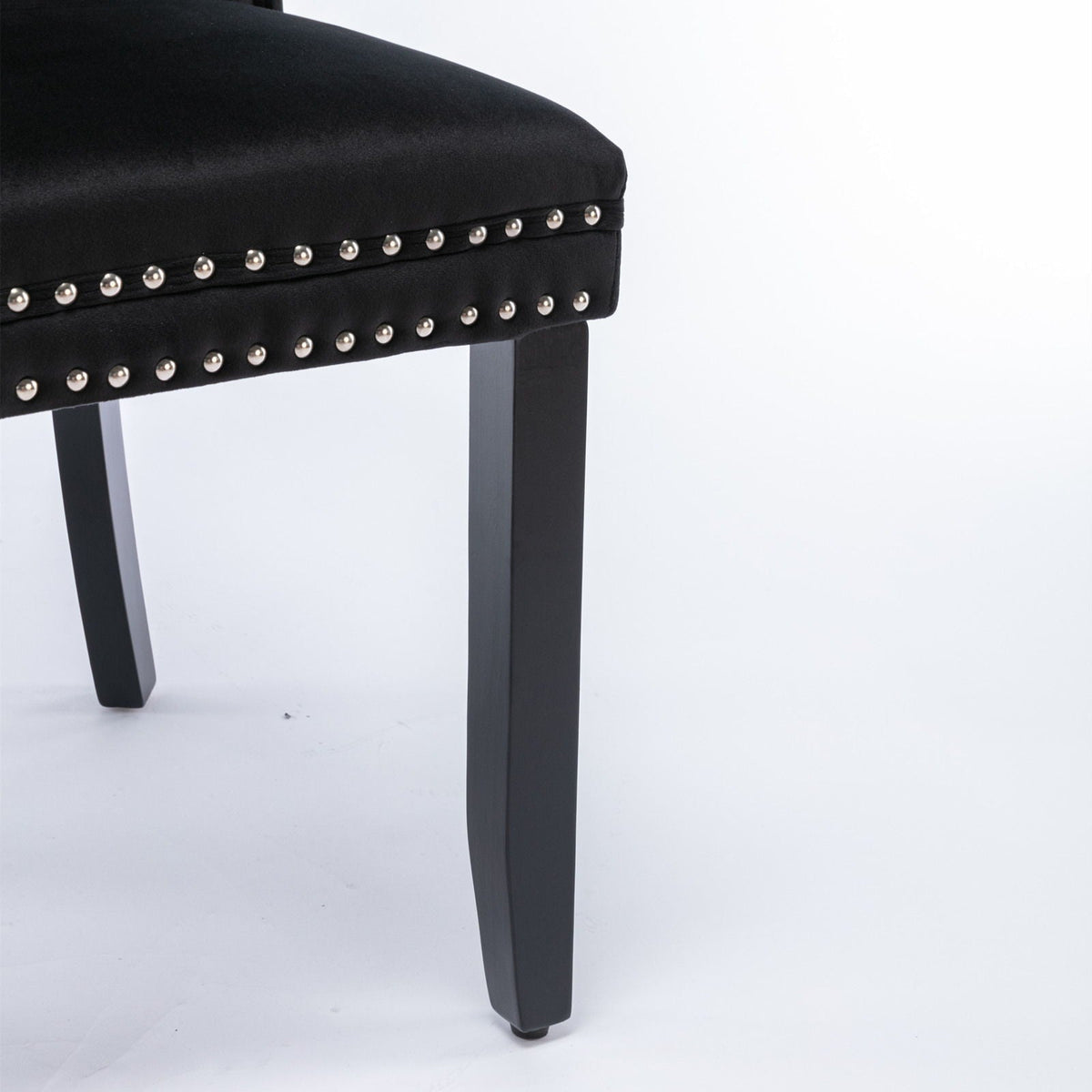 Tufted velvet dining chair set in black with silver nailhead trim, chair leg visible on Tampa Home & Garden Store