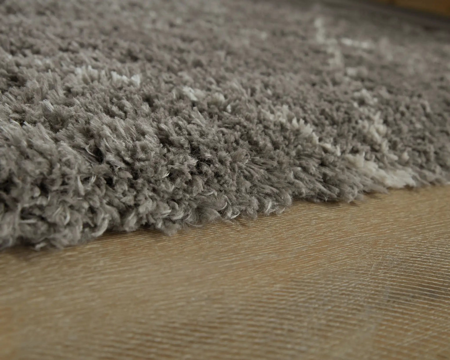 Wrenlow area rug plush gray shag fibers on wood floor by Unique Piece Furniture on Tampa Home & Garden Store