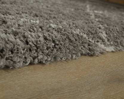 Wrenlow area rug plush gray shag fibers on wood floor by Unique Piece Furniture on Tampa Home & Garden Store