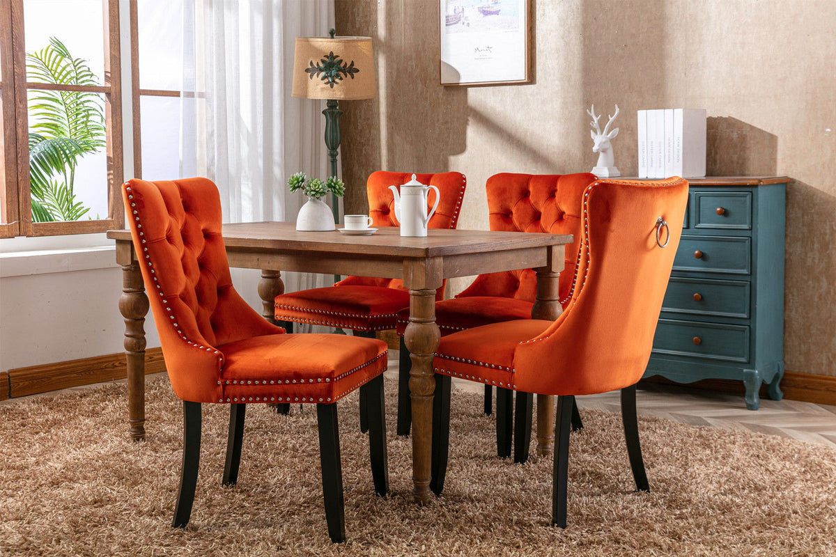 Tufted dining chair set in orange velvet with nailhead trim, four chairs around a rustic wooden table on Tampa Home & Garden Store