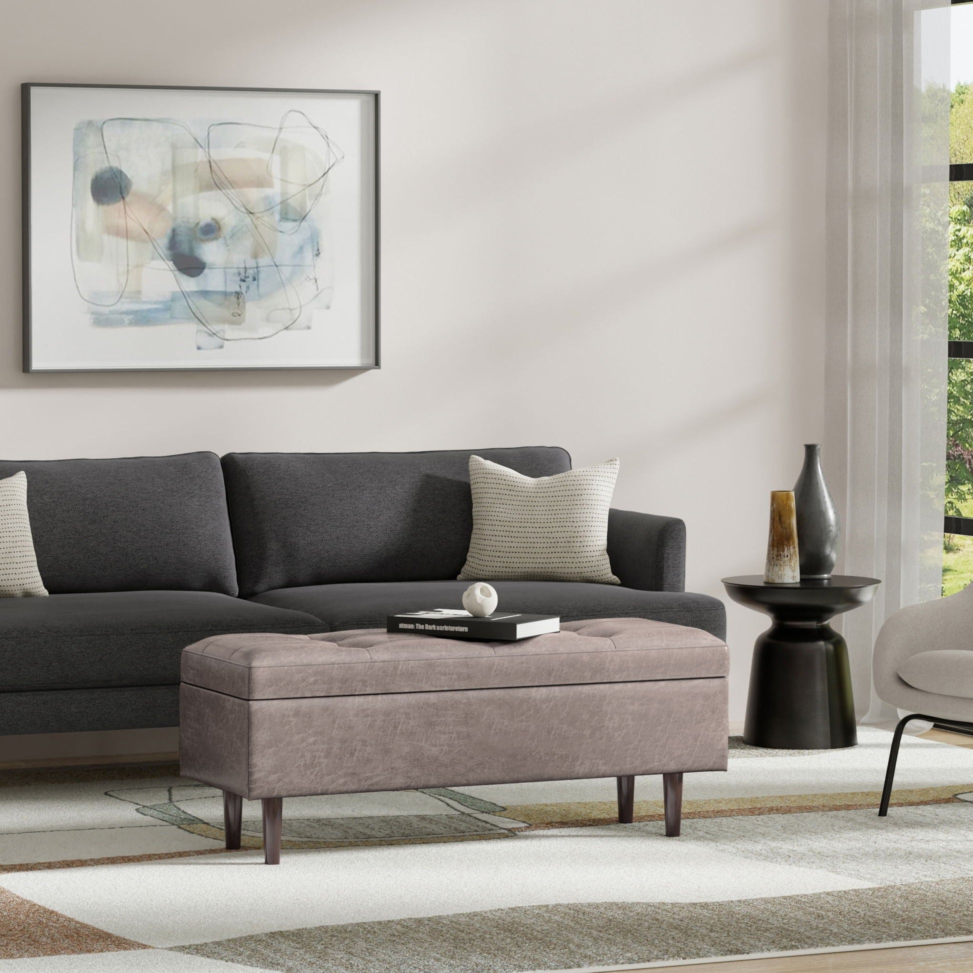 Shay square storage ottoman in gray fabric by Unique Piece Furniture, in front of a dark sofa on Tampa Home & Garden Store